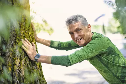 Ein Mann der sich an den Baum lehnt