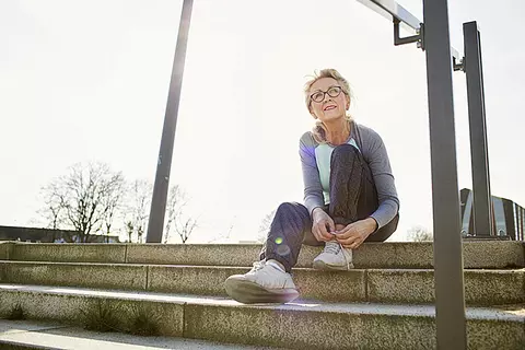 Dame im Sportoutfit sitzende auf Treppe